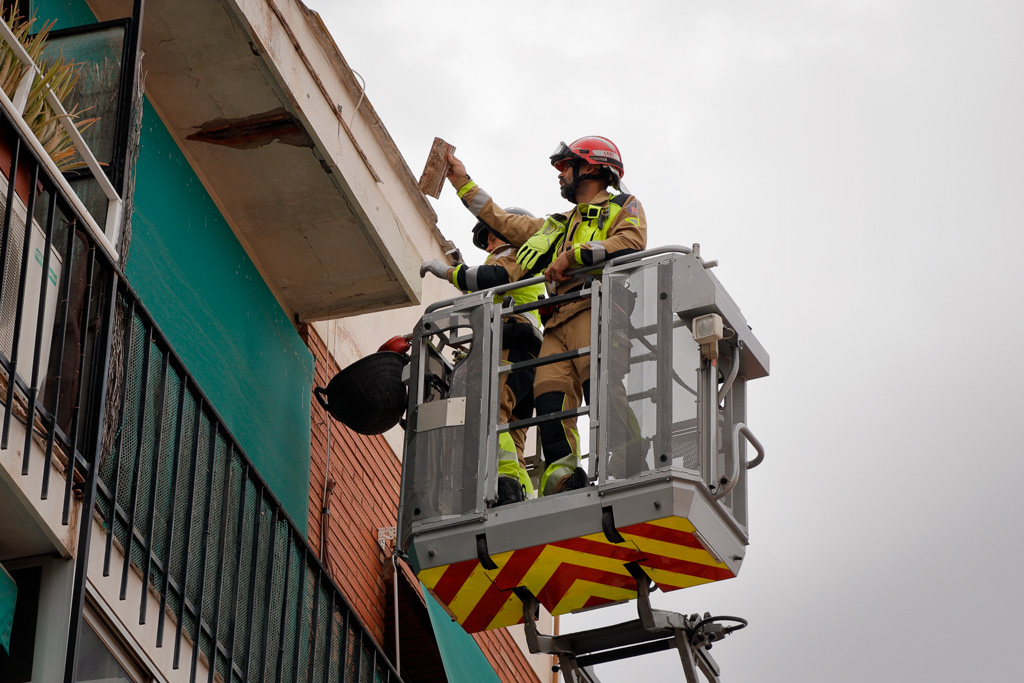 Los bomberos retiran las piezas potencialmente peligrosas que podrían caer.